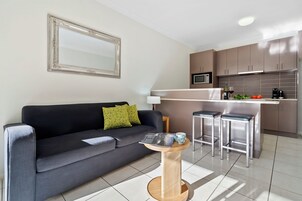 Apartamento executivo, 1 quarto | Área de estar | TV 42 polegadas com canais via satélite, Netflix, serviços de streaming