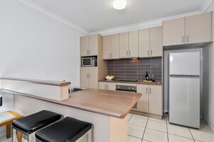 Apartamento executivo, 1 quarto | Cozinha privada | Geladeira grande, micro-ondas, fogão, cooktop