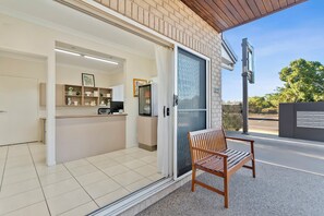 A reception area with a bench, a glass door, and a counter with shelves.