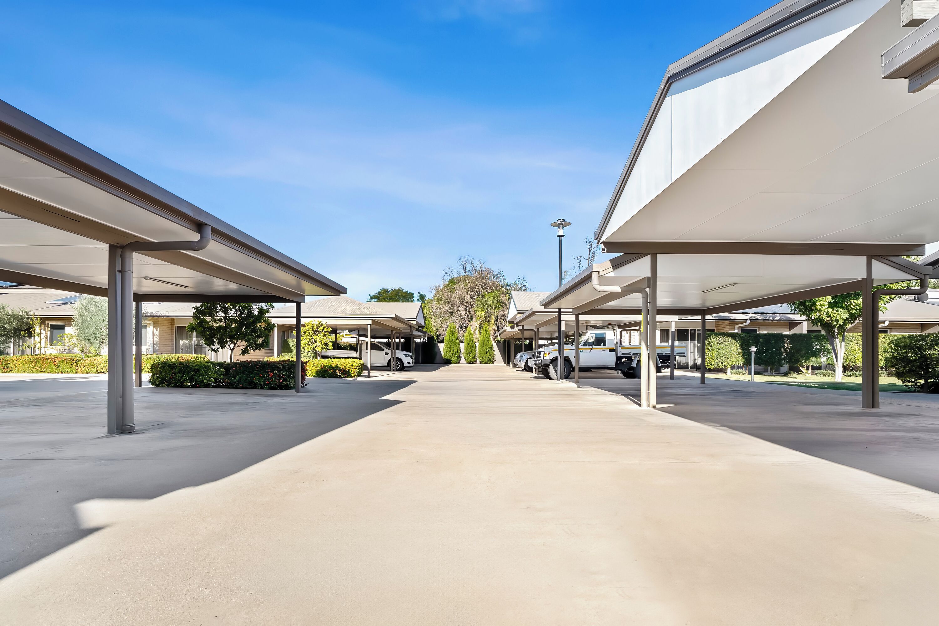 A parking area with covered walkways and a clear sky.
