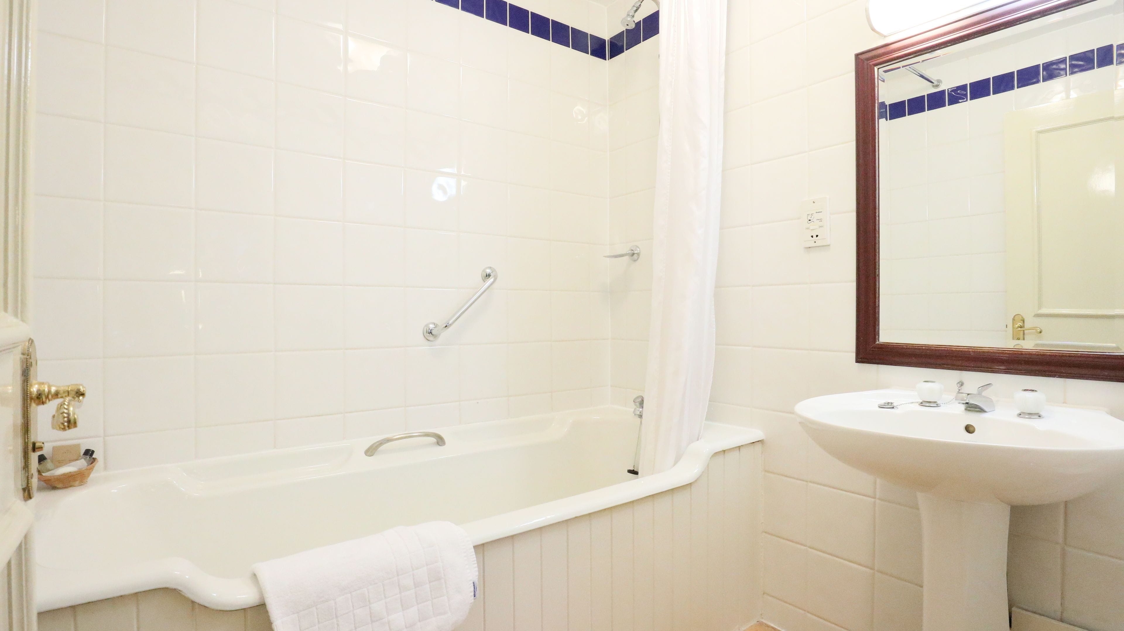A bathroom with a bathtub, a sink, and a mirror.