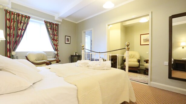 Une chambre d’hôtel avec un grand lit, une chaise, un bureau et un miroir.