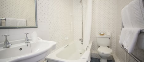A bathroom with a sink, bathtub, toilet, and a mirror.