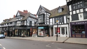 Un bâtiment traditionnel à colombages, avec un magasin au rez-de-chaussée et une boutique de chocolats sur le côté droit.