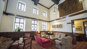 Un hall d’entrée spacieux, doté de hauts plafonds, de grandes fenêtres et d’un mobilier de style traditionnel.