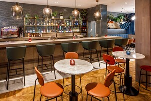 A bar area with multiple seating options, including bar stools and tables, and a variety of bar equipment.