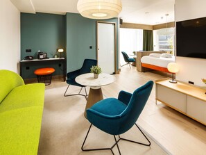 A modern hotel room with a bed, seating area, and a TV. - ibis Styles Edinburgh Centre St Andrew Square (Edinburgh)