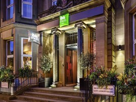 A hotel entrance with a sign for 'ibis Styles Edinburgh Saint Andrew Square.'