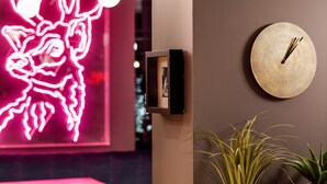 A wall-mounted clock, a neon art piece, and a framed picture. - ibis Styles Edinburgh Centre St Andrew Square (Edinburgh)