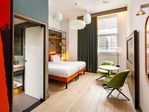 A hotel room with a bed, a desk, a chair, a small table, and a window with curtains. - ibis Styles Edinburgh Centre St Andrew Square (Edinburgh)