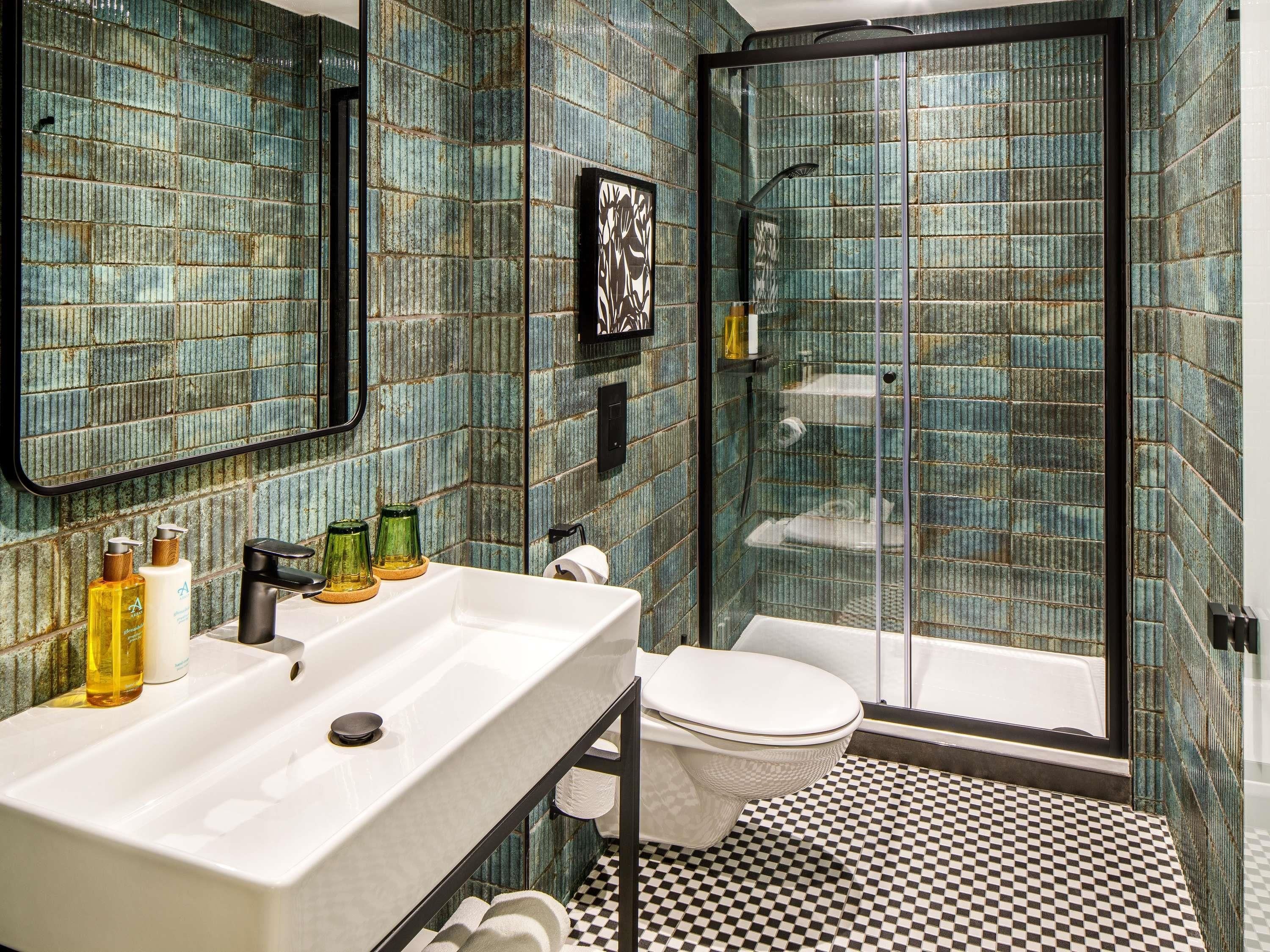 A bathroom with a white sink, a toilet, and a glass-enclosed shower area.