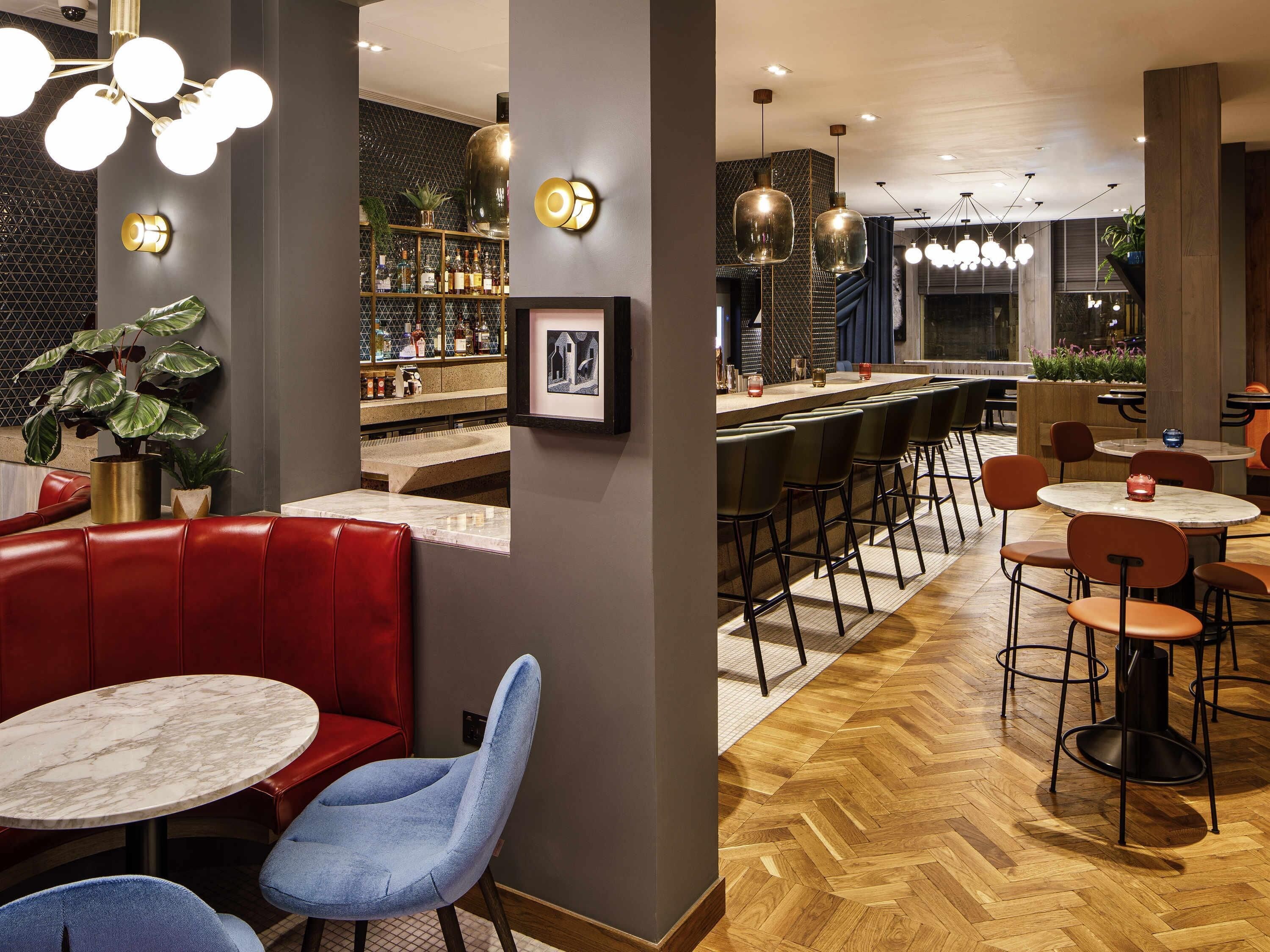Een bar met zitplaatsen, een toog en een visgraatmotief houten vloer.