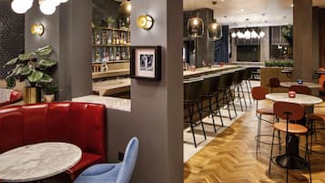 Een bar met zitplaatsen, een toog en een visgraatmotief houten vloer.
