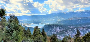 A mountainous landscape with a lake, dense forests, and snow-capped peaks. - High Sierra Condominium (Ruidoso)