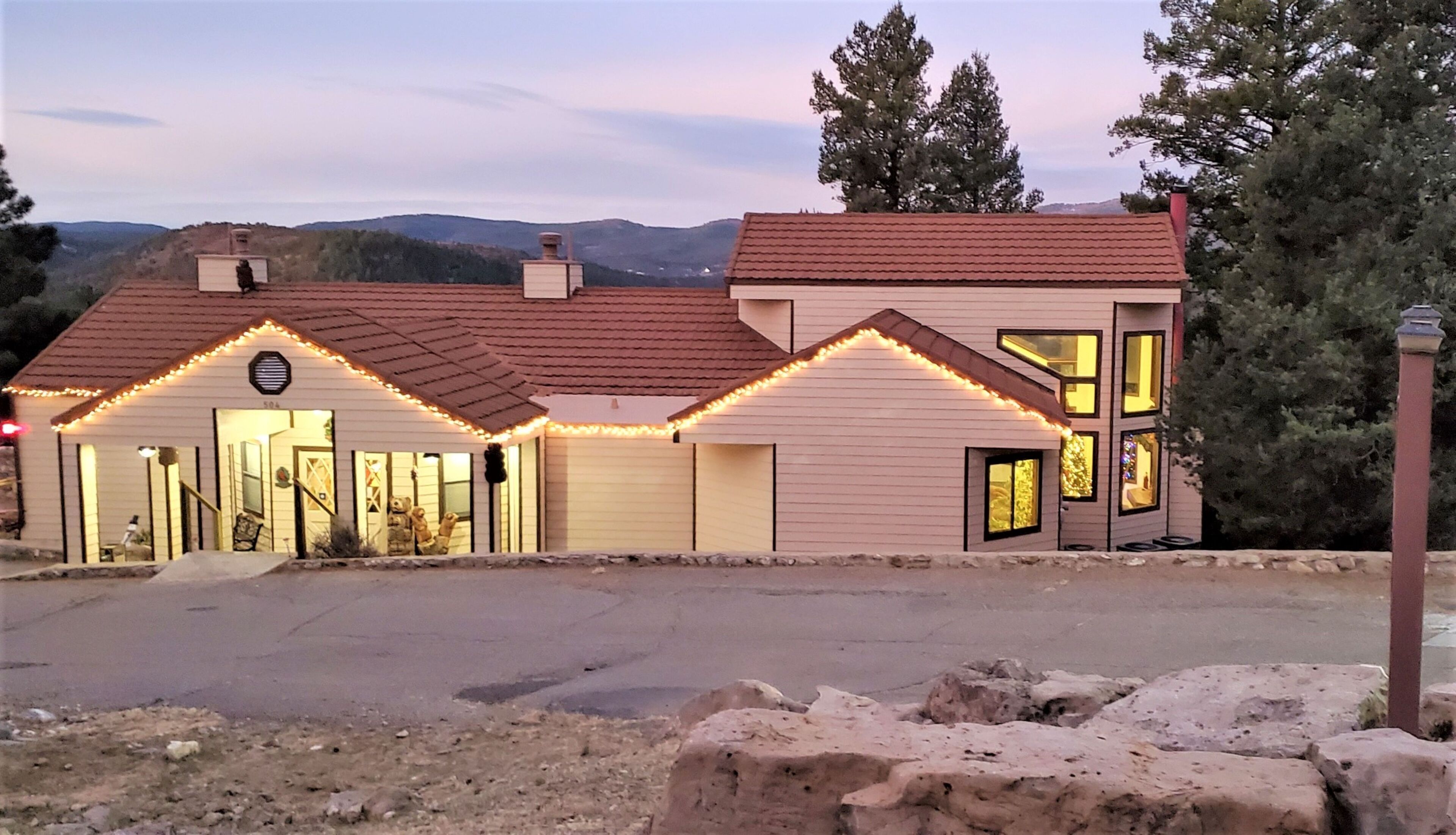 A two-story house with a red-tiled roof, a garage, and a driveway.