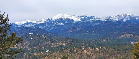 A mountainous landscape with snow-capped peaks and scattered buildings.