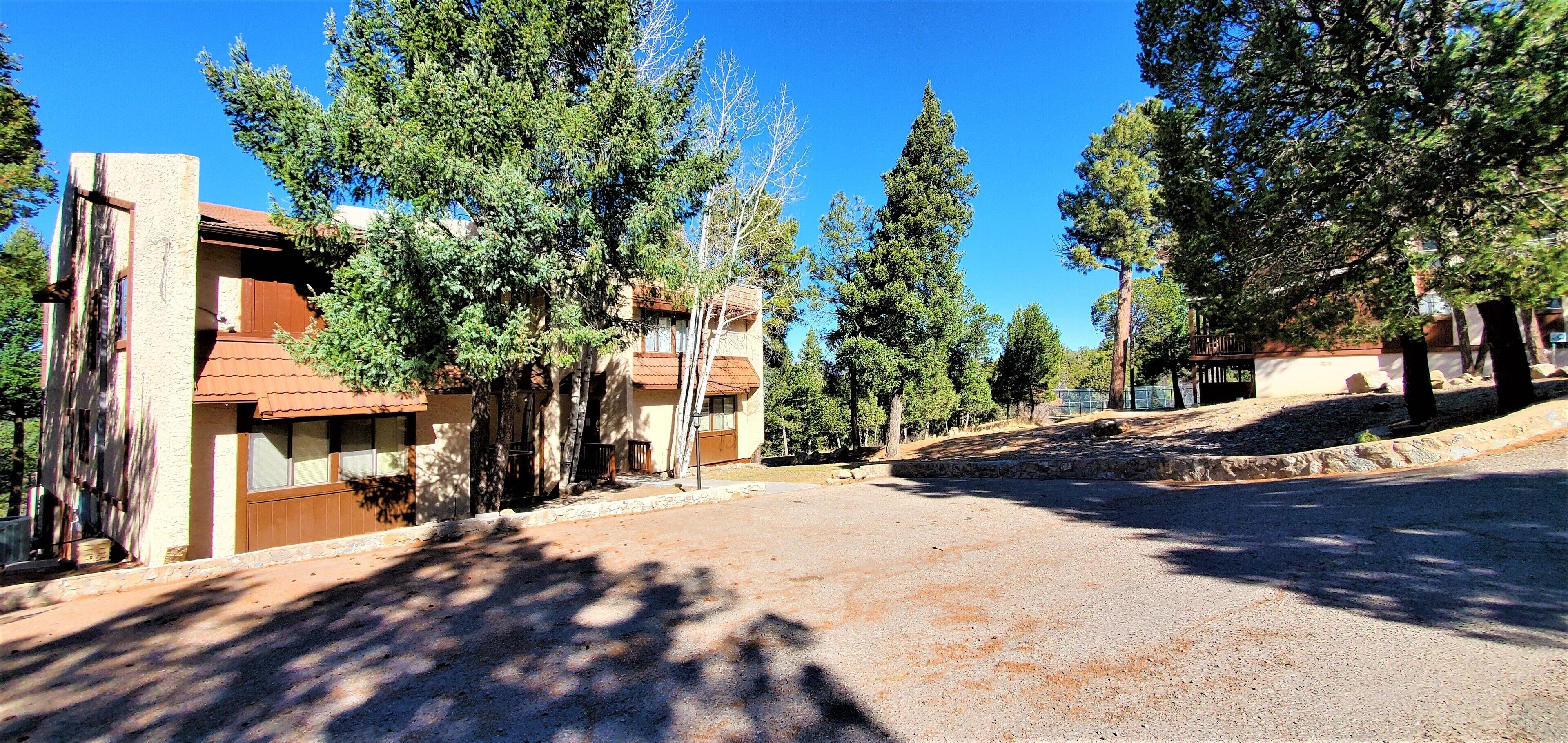 A residential area with houses, trees, and a clear sky.