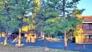 A residential area with two houses, a parking lot, and a red car. - High Sierra Condominium (Ruidoso)