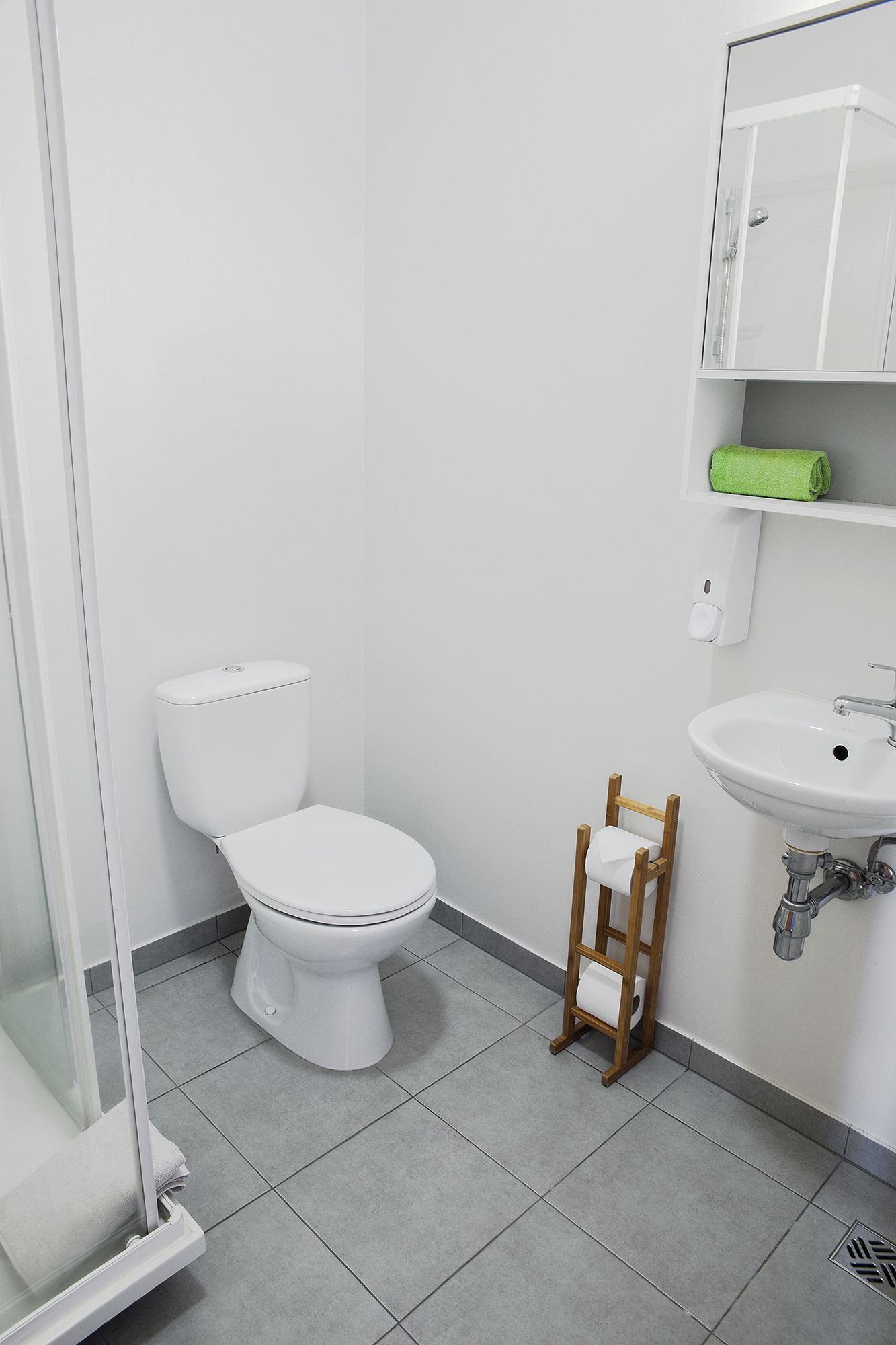 Un baño moderno con inodoro, lavamanos y cabina de ducha.