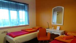A hotel room with two beds, a desk, and a chair. - Grundarfjördur Hostel (Grundarfjörður)