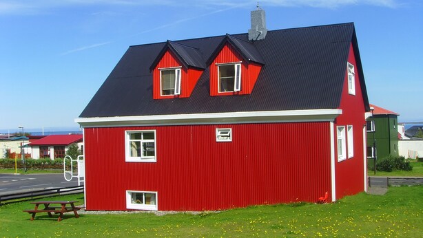 A red house with a black roof, white windows, and a chimney. - Grundarfjördur Hostel (Grundarfjörður)