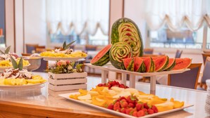 Una mesa de buffet con diversas frutas y verduras, incluyendo sandía y fresas.