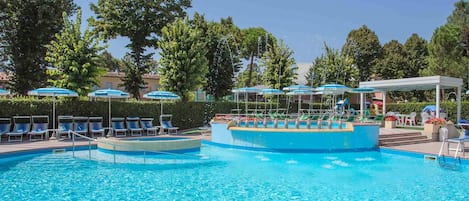 Piscine extérieure en saison, parasols, chaises longues