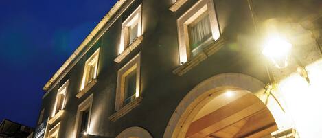 Un edificio con varios pisos, amplias ventanas arqueadas y fachada de vidrio.