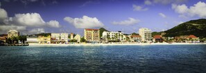 A coastal hotel with multiple buildings, a beach, and a mountain in the background. - Horizon View Beach Hotel (Philipsburg)