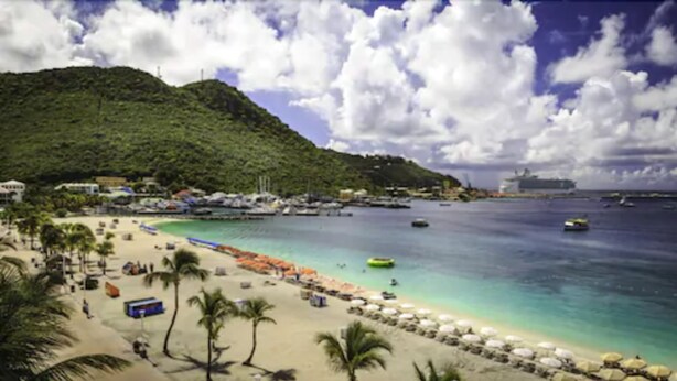 A beach with a clear view of the ocean, a sandy shore, and a mountainous backdrop. - Horizon View Beach Hotel (Philipsburg)