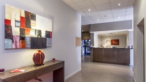 Una cocina moderna con una isla central, una zona de comedor con mesa y sillas, y un espacio de sala de estar con sofá y mesa de centro.