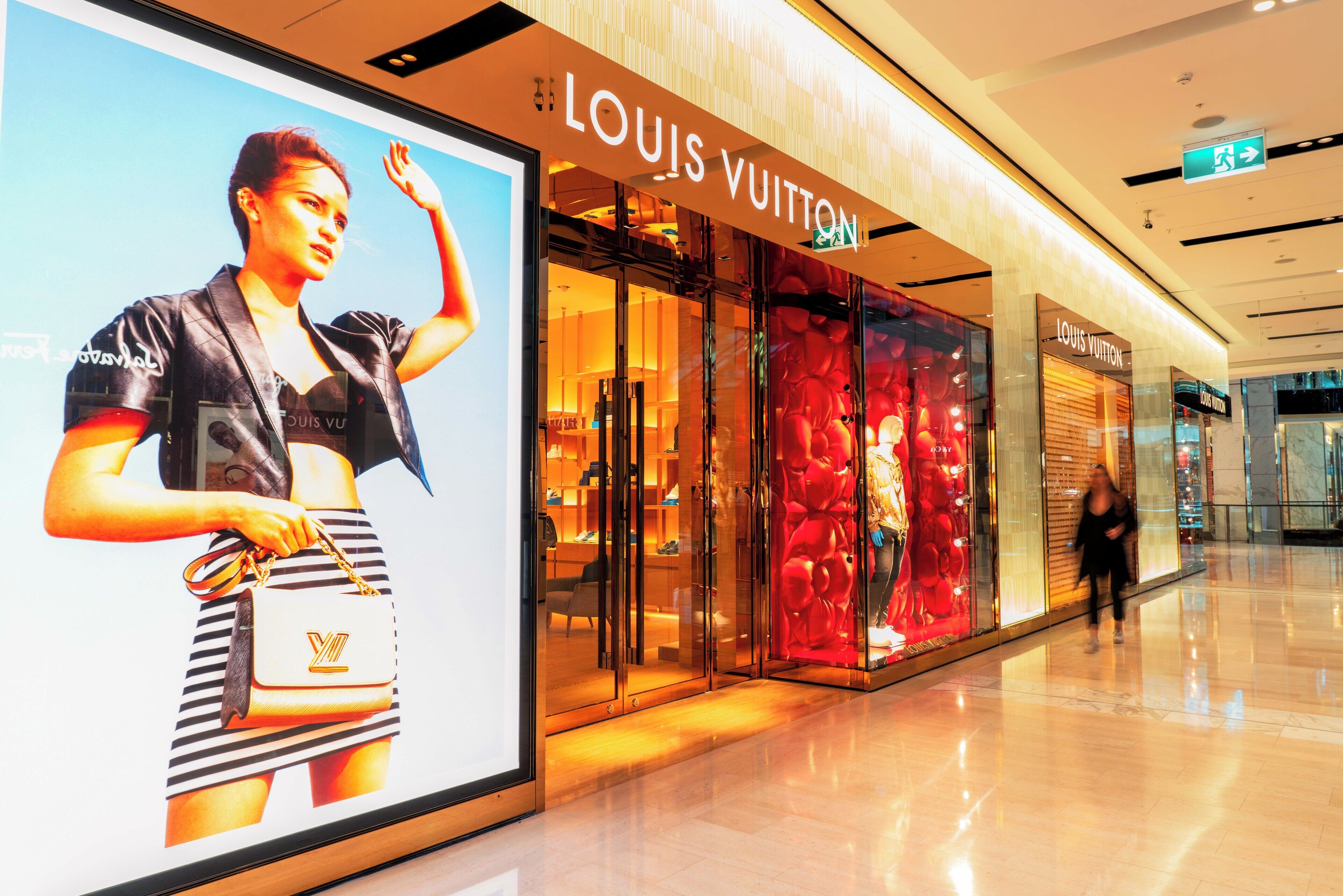 Suuri Louis Vuitton -myymälä, jossa on näyttävä lasijulkisivu ja selkeästi näkyvä kyltti.