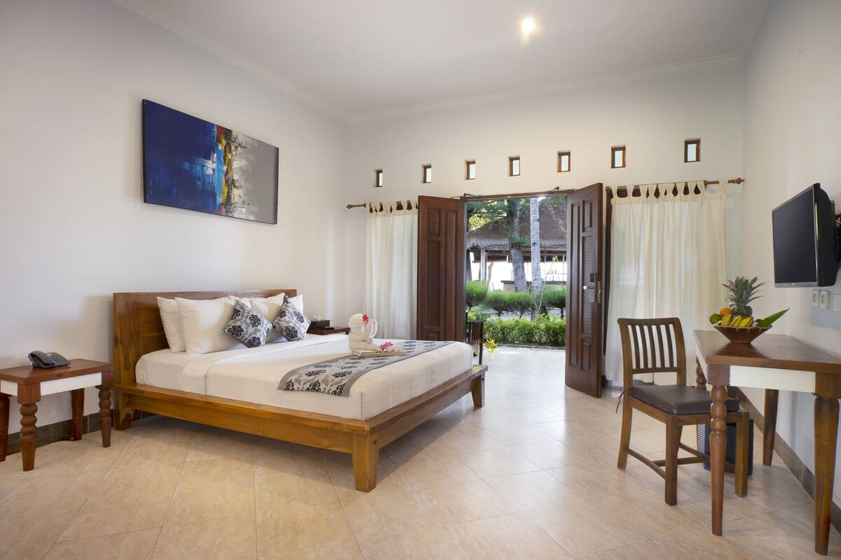 Ein Schlafzimmer mit Bett, Nachttisch und Schreibtisch mit Stuhl.