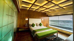 Un dormitorio moderno con una cama grande, paneles de madera, vista al mar y un diseño de techo único.