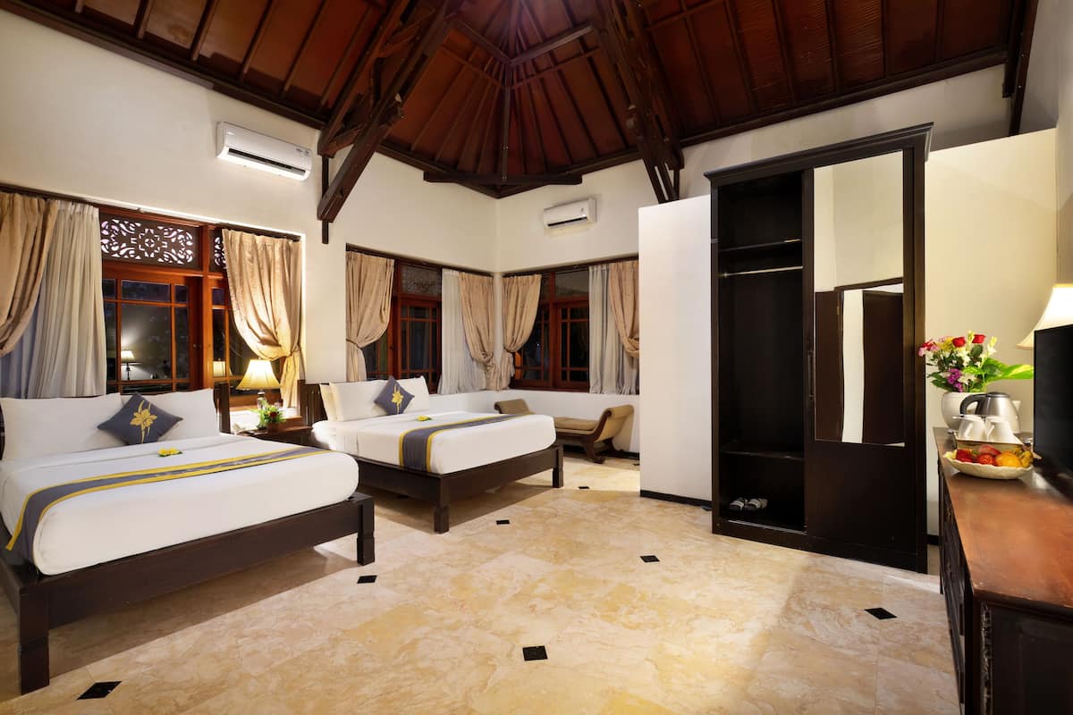 A hotel room with two beds, a wooden ceiling, and a tiled floor.