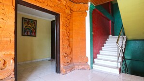 A staircase with a metal handrail, a tiled floor, and a door leading to another room. - Bali Senia Hotel (Denpasar)