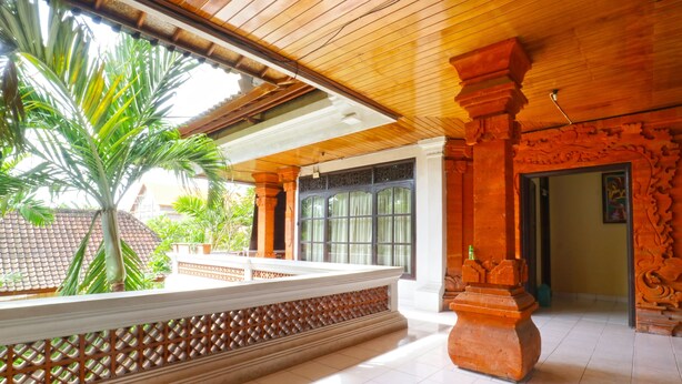 A spacious indoor area with a tiled floor, a wooden ceiling, and a large window. - Bali Senia Hotel (Denpasar)