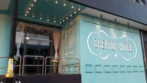 The exterior of The Creator Hotel with a teal facade, a visible entrance, and a sign indicating the hotel lobby. - Creator Hotel (Kulai)