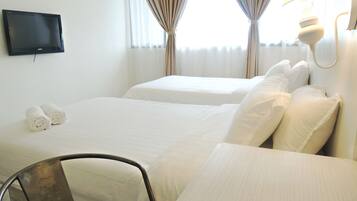 A hotel room with two beds, a flat-screen TV mounted on the wall, a desk, and a chair.