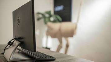 A desktop computer on a desk with a keyboard and a monitor.