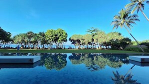 A pool with clear reflections of palm trees and a clear blue sky. - Temple Tree Resort & Spa (Induruwa)
