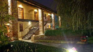 A two-story building with a stone facade, a staircase, and a well-lit exterior. - Hotel Mulino Grande (Cusago)