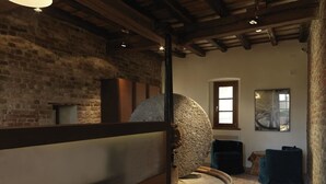 A rustic interior with exposed brick walls, a stone mill, and wooden furniture. - Hotel Mulino Grande (Cusago)