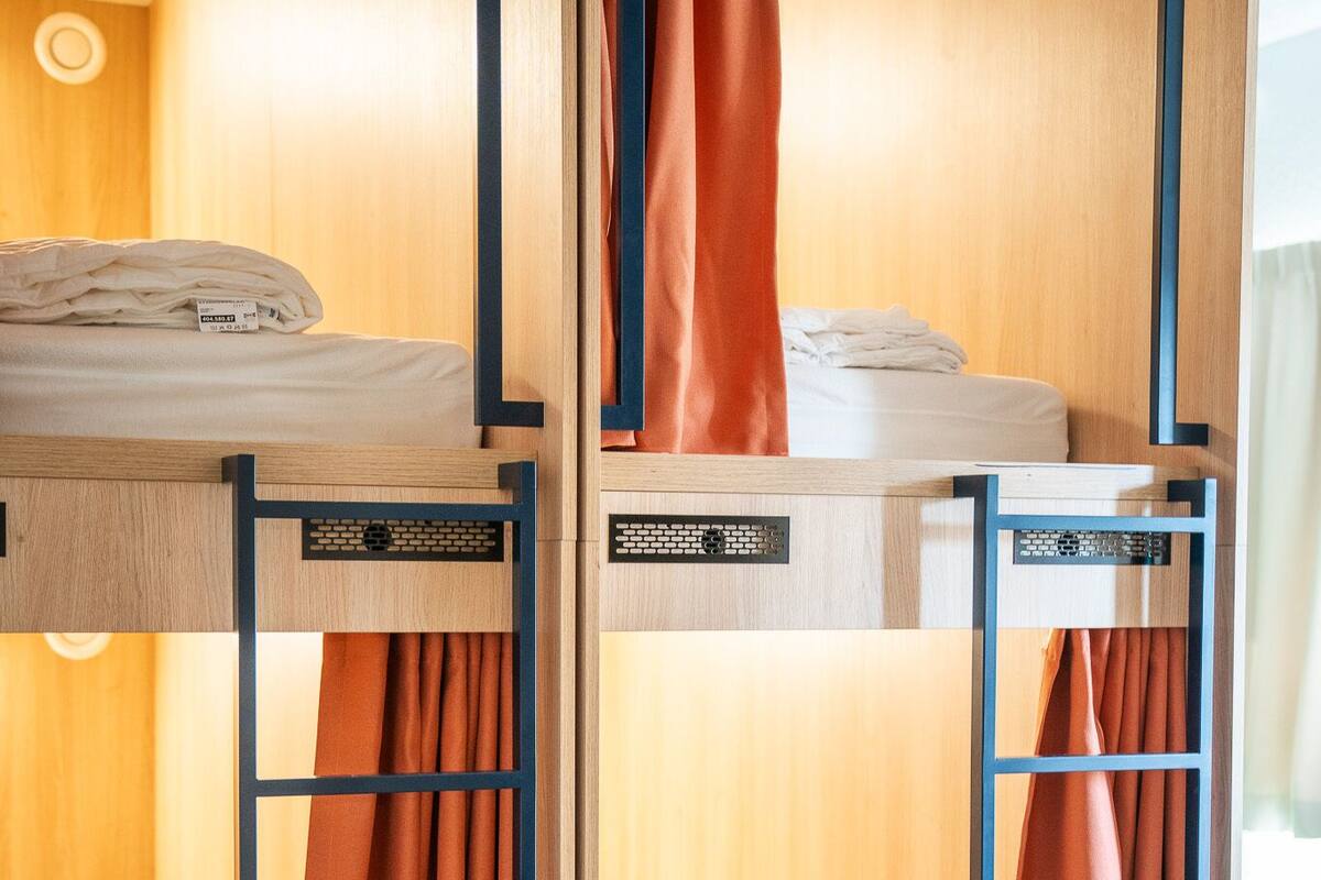 A bunk bed room with wooden walls and a window.