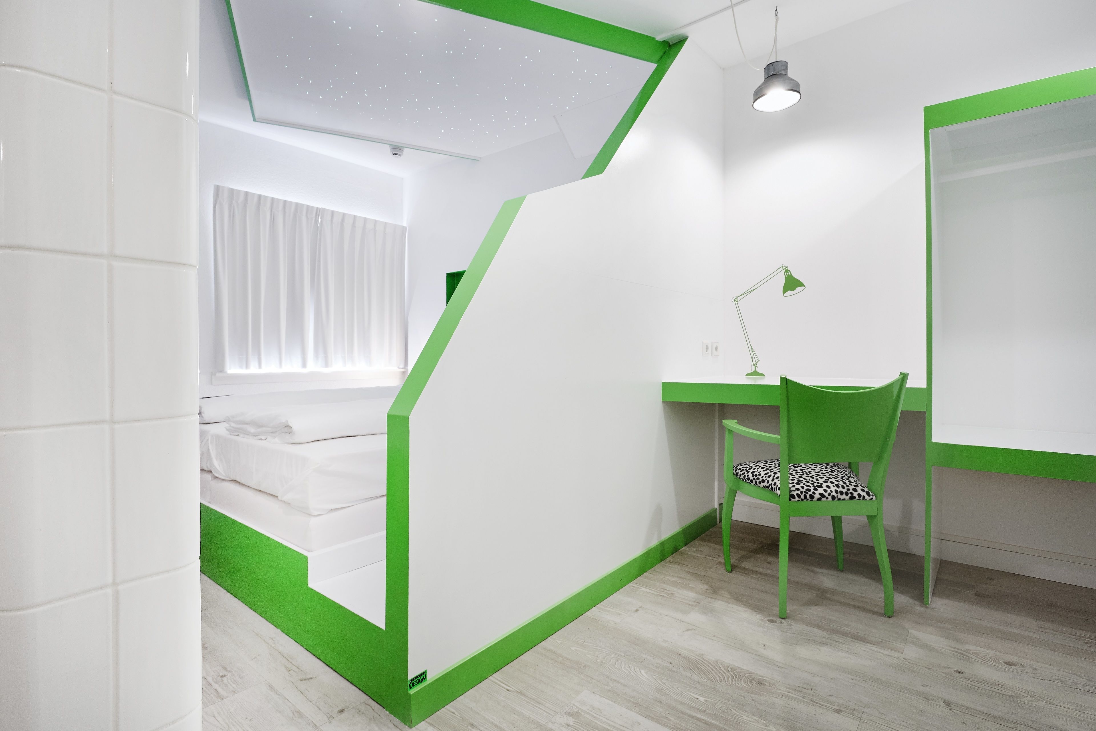 Een kamer met een bed, een bureau en een stoel.