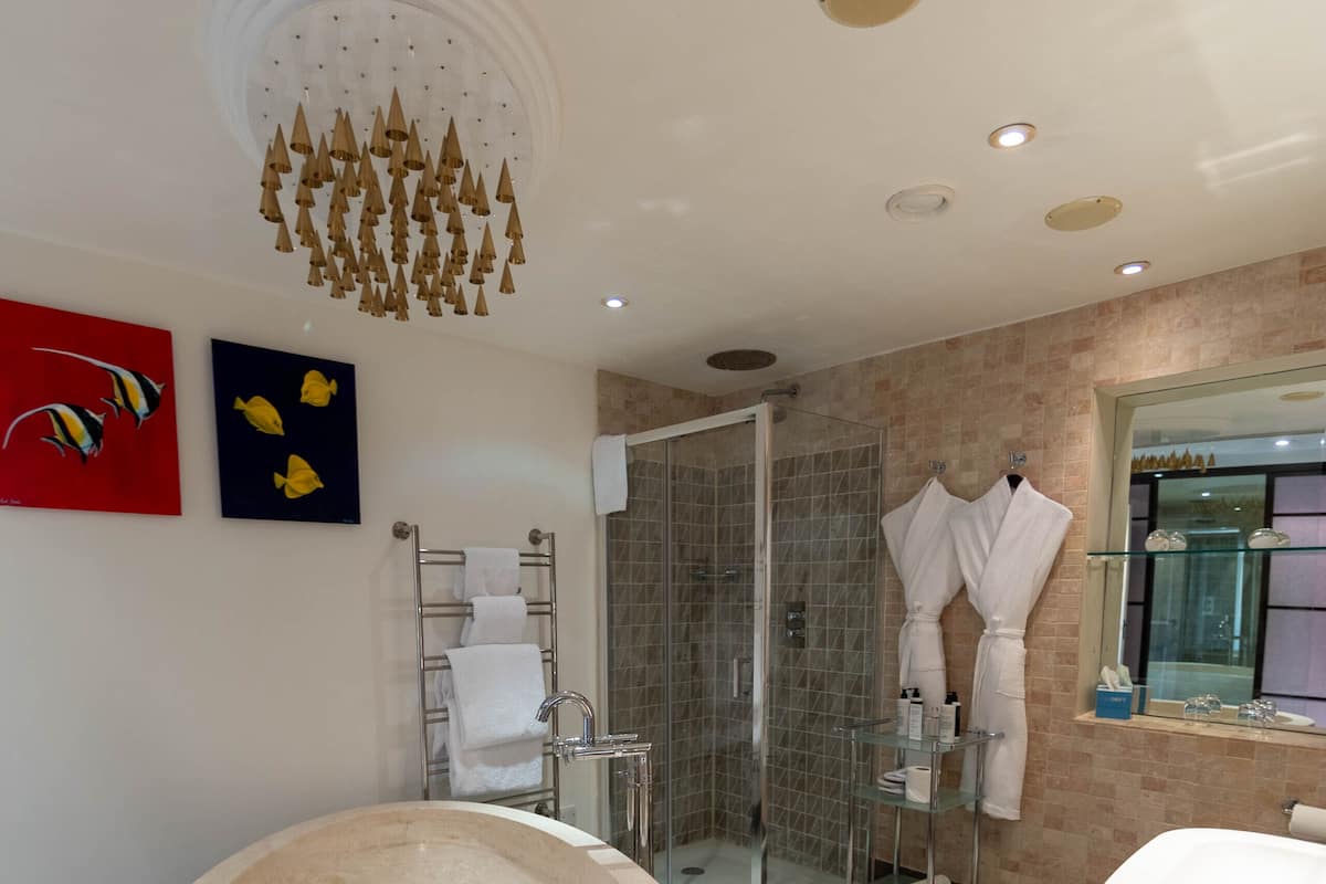 A modern bathroom with a large freestanding bathtub, a glass shower enclosure, and a vanity with a mirror.
