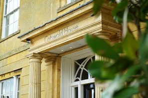 The entrance of Cotswold House with classical architecture, including columns and a prominent entrance door.