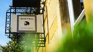 A sign for "BISTRO ON THE SQUARE" mounted on a building.
