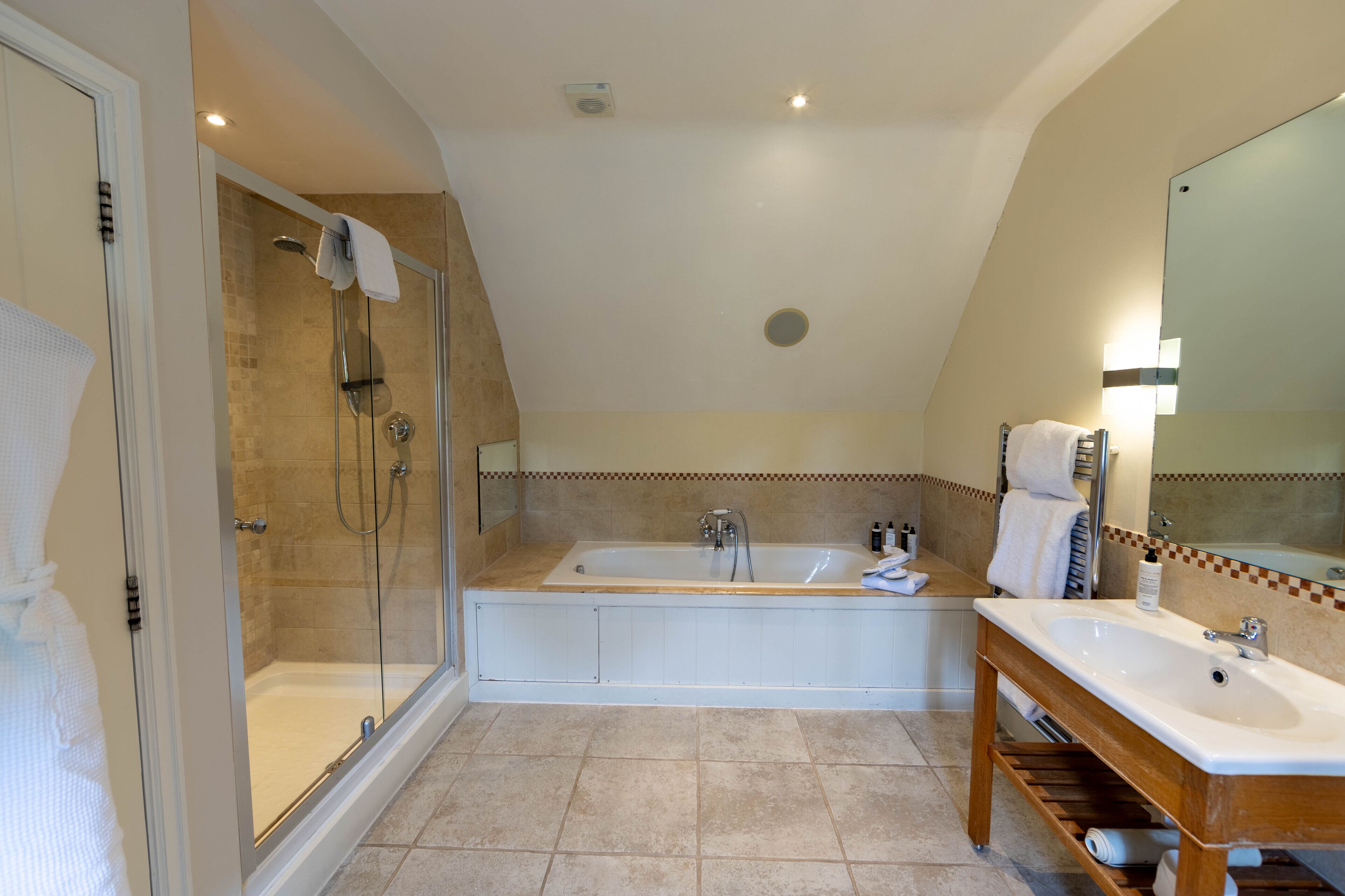 Une salle de bain moderne dotée d’une douche à parois de verre, d’une baignoire sur pieds et d’un meuble-lavabo avec un miroir.