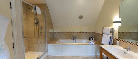 Une salle de bain moderne dotée d’une douche à parois de verre, d’une baignoire sur pieds et d’un meuble-lavabo avec un miroir.